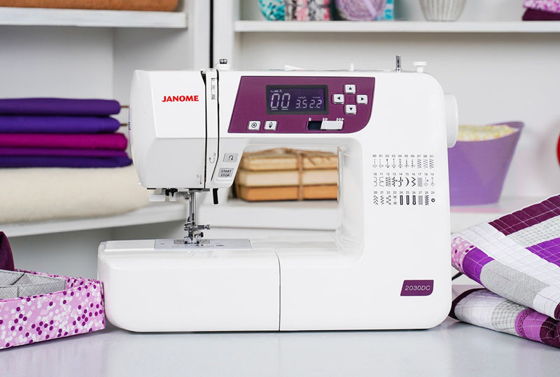 Janome 2030DC-G computerized sewing machine in grapevine purple front profile view showing the control dashboard.