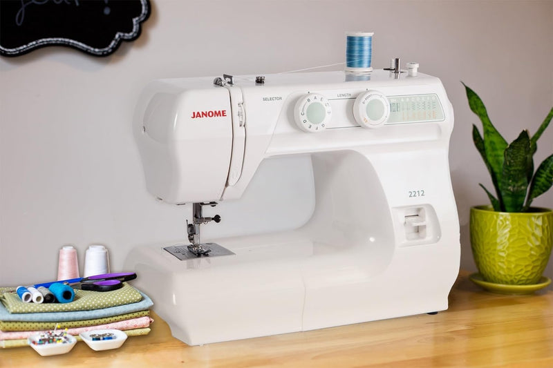 Janome 2212 mechanical sewing machine front view showcasing the stitch selection dial and clean white design.