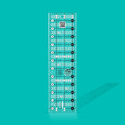 Creative Grids Quick Trim 3.5-inch by 12.5-inch rectangle quilting ruler laid flat over patterned fabric.