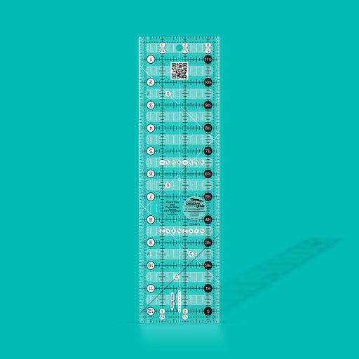 Creative Grids Quick Trim 3.5-inch by 12.5-inch rectangle quilting ruler laid flat over patterned fabric.