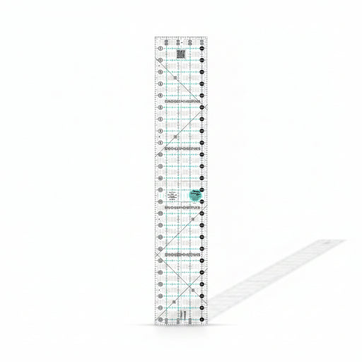 Creative Grids Quick Trim Two 4.5-inch by 24.5-inch long acrylic ruler laid across a folded bolt of fabric.