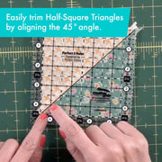 Creative Grids Perfect 5 square quilting ruler placed directly over a 5-inch fabric charm pack square.