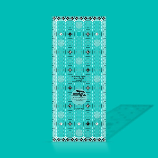 Creative Grids Itty-Bitty Eights 3-inch by 7-inch rectangle quilting ruler sitting over a miniature patchwork block.
