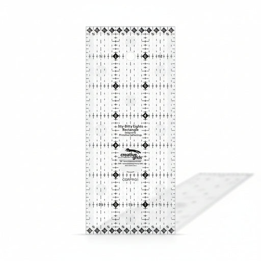 Creative Grids Itty-Bitty Eights 3-inch by 7-inch rectangle quilting ruler sitting over a miniature patchwork block.