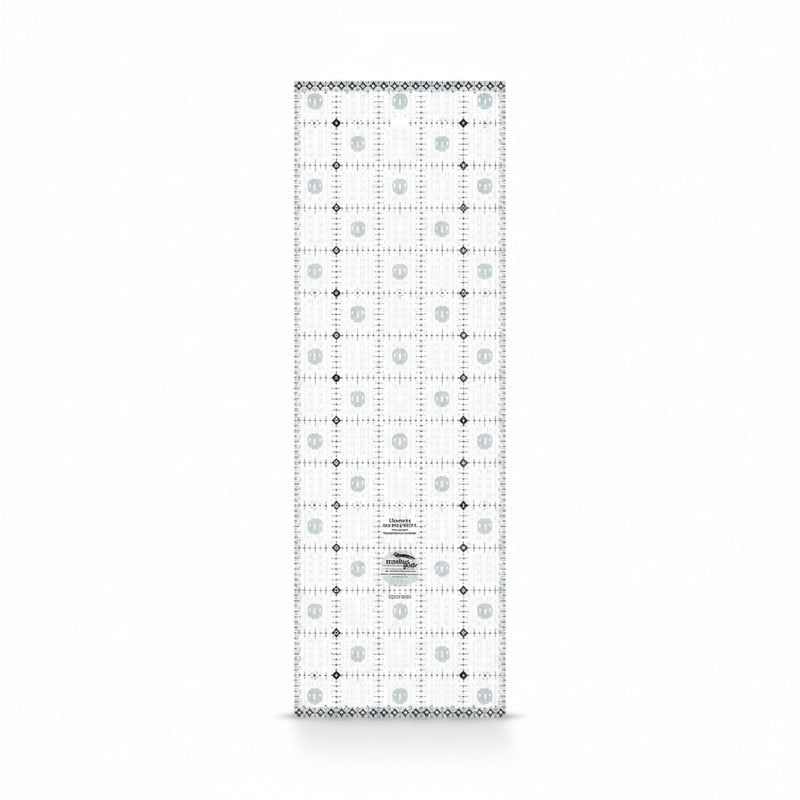 Creative Grids Charming Itty-Bitty Eights 5-inch by 15-inch rectangle quilting ruler sitting over a charm pack fabric layout.