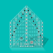 Creative Grids House Quilt Ruler placed over a freshly cut fabric house block.