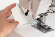 Janome CoverPro 3000P professional cover hem machine front view showing the extra long bed and thread cones.