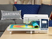 brother-pacesetter-innov-is-ps700-sewing-machine-stitching-brightly-colored-quilt-on-extension-table-in-living-room