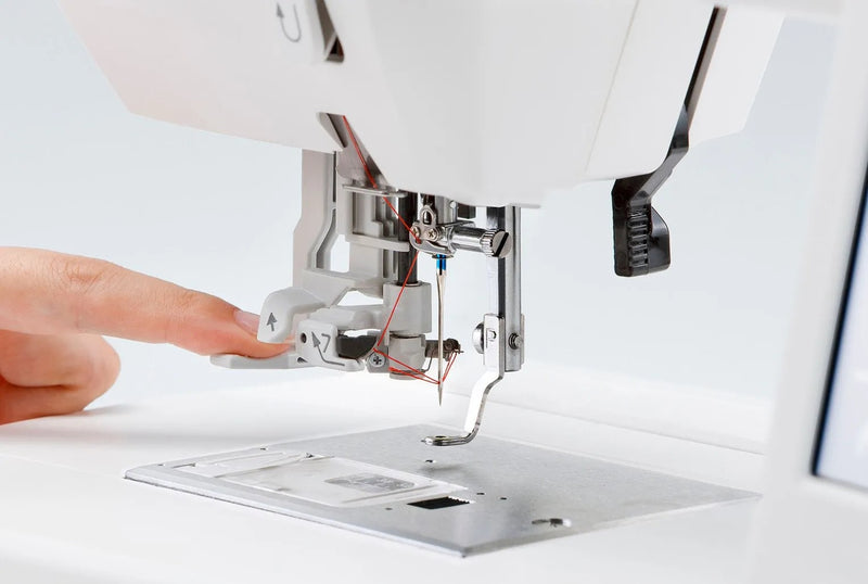 Janome Memory Craft 100E computerized embroidery machine front view showing color touchscreen.
