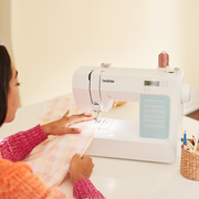 brother-cp60x-computerized-sewing-machine-lifestyle-view-on-white-table-with-pink-and-white-plaid-fabric