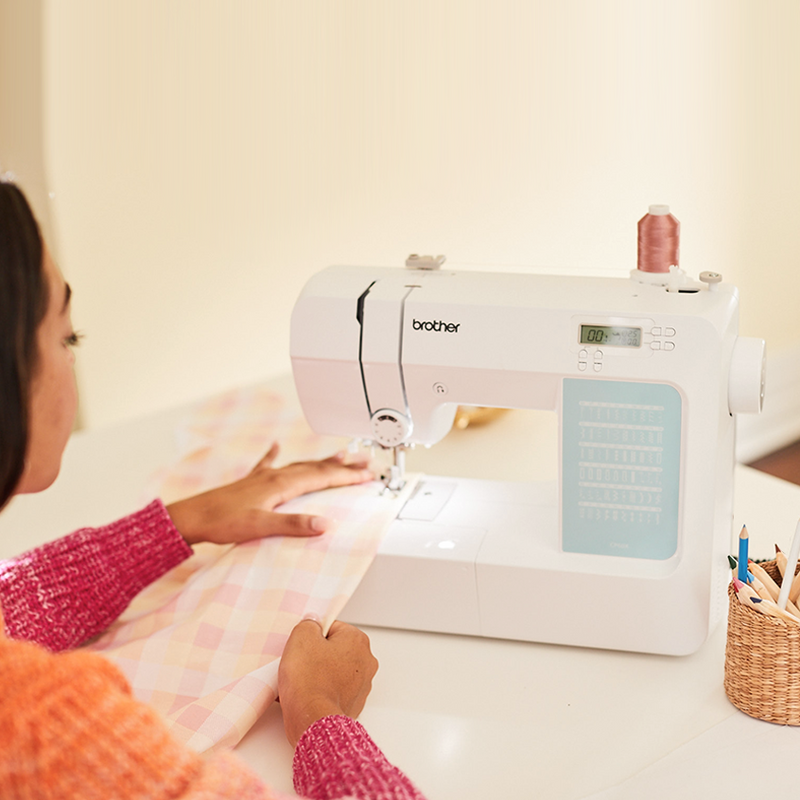 brother-cp60x-computerized-sewing-machine-lifestyle-view-on-white-table-with-pink-and-white-plaid-fabric