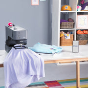 brother-skitch-pp1-single-needle-embroidery-machine-on-table-with-artspira-mobile-app-displayed-on-smartphone