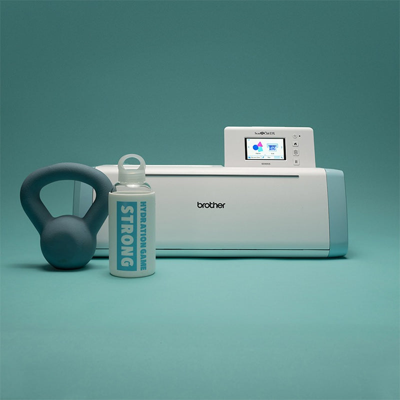 brother-scancut-dx-sdx85s-cutting-machine-front-view-with-light-blue-kettlebell-and-white-hydration-game-strong-water-bottle