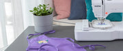 brother-pe545-embroidery-machine-on-table-next-to-finished-purple-apron-with-floral-embroidery
