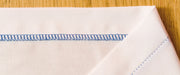 close-up-blue-blind-hem-stitch-pattern-on-white-folded-fabric