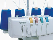 brother-lock-1034d-serger-close-up-view-of-color-coded-tension-dials-with-four-blue-thread-spools