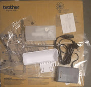 overhead-view-brother-airflow-3000-air-serger-unboxing-accessories-including-foot-controller-and-power-cord-over-cardboard-box