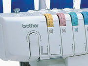 brother-lock-1034d-serger-extreme-close-up-view-of-yellow-pink-teal-and-blue-numbered-tension-dials