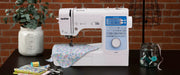 brother-innov-is-ns80e-portable-sewing-machine-with-floral-fabric-and-notions-on-craft-room-worktable