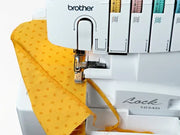 brother-lock-1034d-serger-overhead-view-showing-yellow-patterned-fabric-being-stitched-and-trimmed
