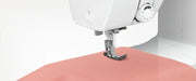 brother-cp60x-computerized-sewing-machine-close-up-angled-view-focusing-on-needle-feeding-peach-fabric
