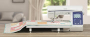 brother-innov-is-bq950-sewing-machine-stitching-patterned-quilt-on-white-extension-table-front-view