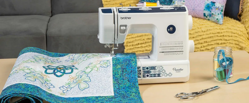 brother-pacesetter-ps200t-sewing-and-quilting-machine-stitching-on-blue-and-white-quilt-top-with-notions-jar
