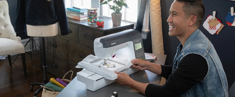 lifestyle-view-of-man-smiling-while-operating-brother-innov-is-ns2850d-combo-sewing-embroidery-machine