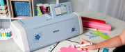 close-up-user-hand-weeding-pink-floral-vinyl-cutout-next-to-brother-scanncut-dx-innov-is-edition-sdx325-machine