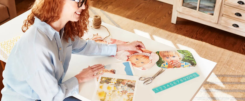 woman-arranging-custom-printed-baby-photos-on-table-in-front-of-brother-printmoda-studio-fabric-printer-hl-jf1