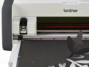 brother-scancut-dx-sdx85c-cutting-machine-close-up-view-of-standard-tack-adhesive-mat-with-hand-and-green-polka-dot-fabric