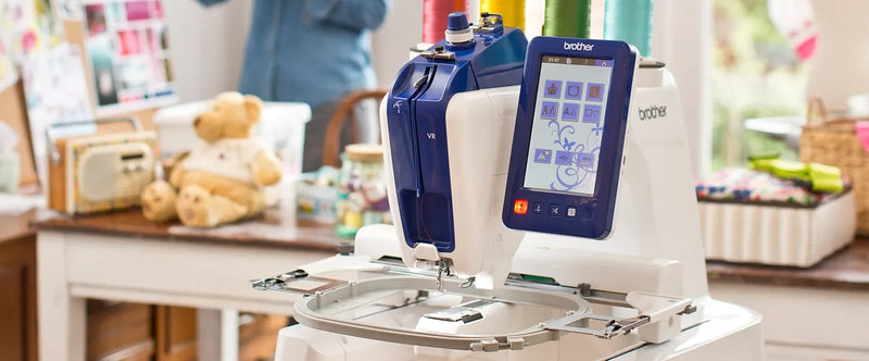 brother-persona-prs100-single-needle-embroidery-machine-on-table-with-teddy-bear-workspace-background