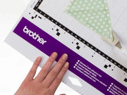brother-scancut-dx-sdx85c-cutting-machine-close-up-view-of-blade-holder-and-cutting-mat-with-black-paper-cutout