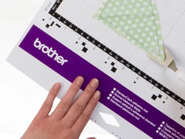 brother-scancut-dx-sdx85c-cutting-machine-close-up-view-of-blade-holder-and-cutting-mat-with-black-paper-cutout
