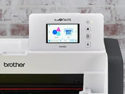brother-scancut-dx-sdx85c-cutting-machine-close-up-view-of-hand-holding-auto-blade-holder-next-to-purple-standard-tack-mat