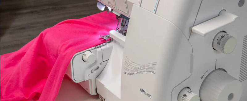 brother-air1800-air-serger-angled-front-view-infographic-highlighting-challenging-materials-with-pink-polka-dot-fabric