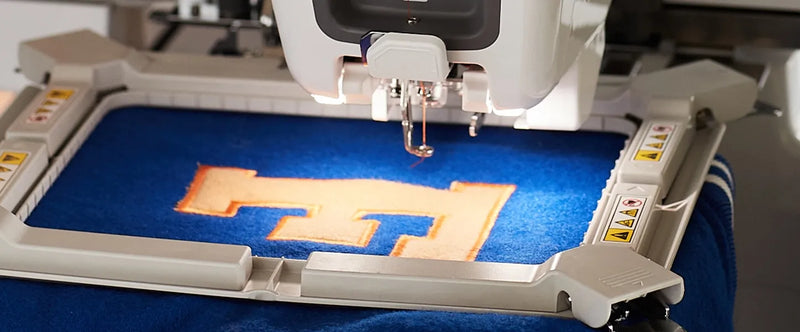 close-up-brother-entrepreneur-one-pr1x-single-needle-embroidery-machine-stitching-letter-e-on-blue-fabric