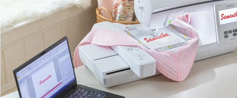 laptop-running-embroidery-software-next-to-brother-innov-is-nq1700e-embroidery-machine-stitching-samantha-on-pink-quilt