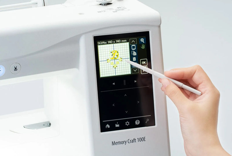 Janome Memory Craft 100E computerized embroidery machine front view showing color touchscreen.
