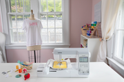 brother-innov-is-ns1250e-embroidery-machine-on-craft-table-next-to-dress-form-showing-embroidered-love-shirt