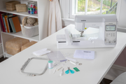 high-angle-view-brother-innov-is-ns1250e-embroidery-machine-with-unboxing-accessories-and-tools-kit-on-white-desk