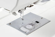 Janome Memory Craft 100E computerized embroidery machine front view showing color touchscreen.