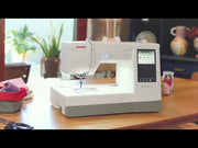 Janome Memory Craft 100E computerized embroidery machine front view showing color touchscreen.