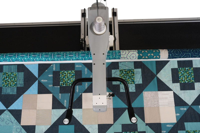 Janome Quilt Maker 15 compact longarm quilting machine head highlighting the LCD monitor and ergonomic handlebars.